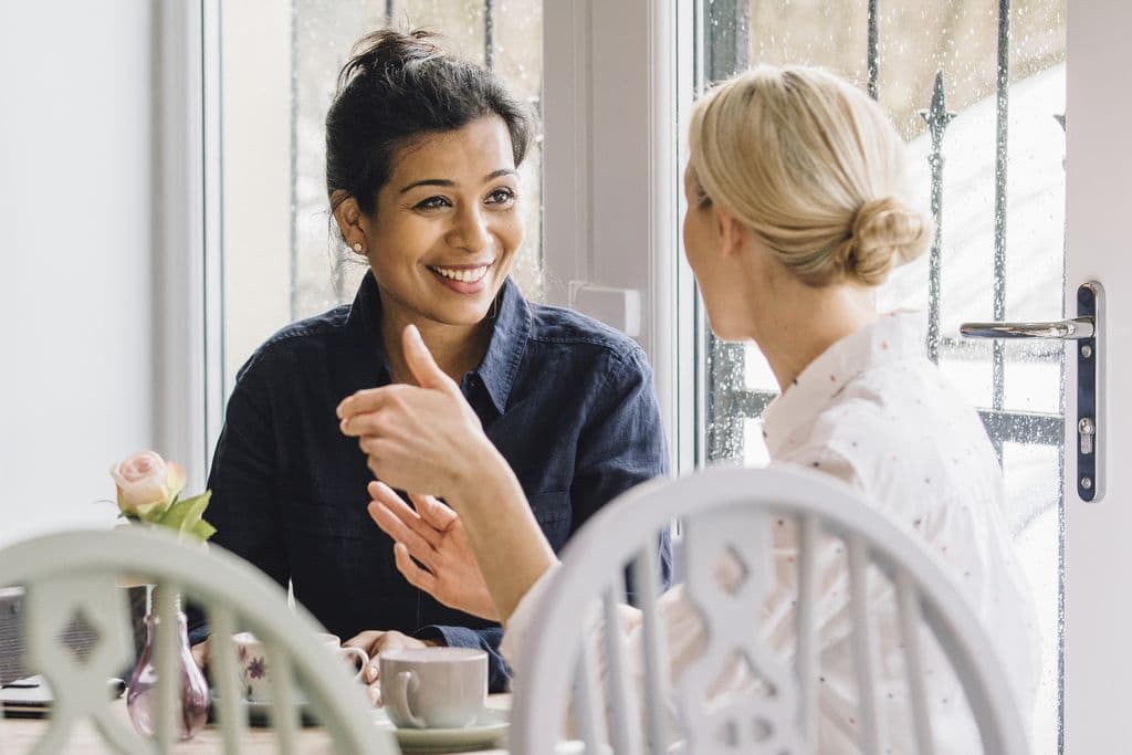 two women talking and eating